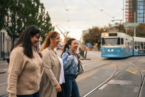 Glada resenärer vid Järntorget, Göteborg, med spårvagnen i bakgrunden."